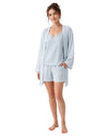 Woman wearing a light blue pajama set with a matching robe