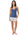Woman wearing a blue lace-trim camisole pajama set with floral print shorts and matching lightweight robe.