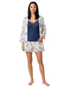 Woman wearing a blue lace-trim camisole pajama set with floral print shorts and matching lightweight robe
