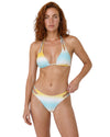 Woman wearing a pastel ombre triangle bikini set with blue and yellow gradient tones, adjustable tie straps,