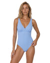 Model wearing a sky blue ribbed one-piece swimsuit with a wrap-style neckline, wide straps, and open scoop back.