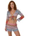 Model wearing multicolor knit beach cover-up shorts with a relaxed fit and vibrant zigzag pattern in pink, blue, red, and neutral tones.
