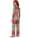 Model wearing a multicolor knit tie-front cover-up top with long sleeves and vibrant zigzag pattern in pink, blue, red, and neutral tones.