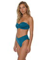Model wearing a teal bandeau bikini set with a twisted front top, high-waisted crossover bikini bottom, and smooth fitted silhouette.