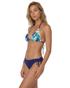 Model wearing a blue tropical print triangle bikini set with adjustable tie straps and side-tie bottoms.