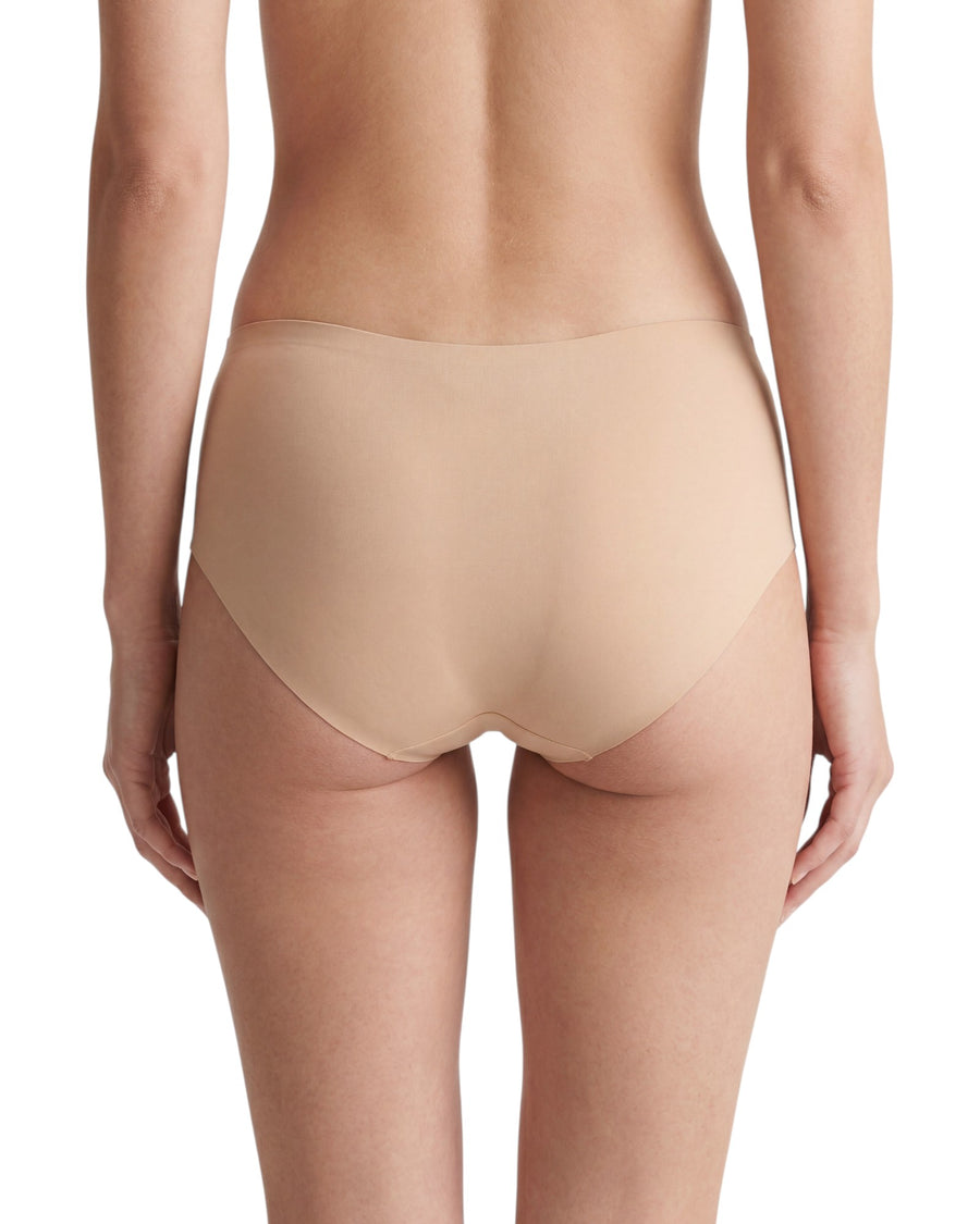 Women's nude seamless mid-rise brief featuring laser-cut edges, full back coverage, and a smooth invisible finish for everyday wear.