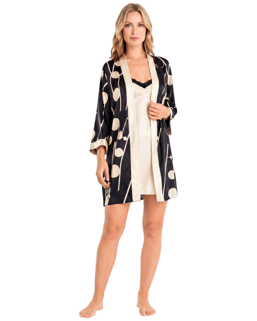 A woman modeling a black and cream floral print robe over a cream slip dress