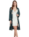Women's satin sleepwear set featuring an ivory lace-trim chemise with adjustable straps and a matching dark green floral print satin robe.