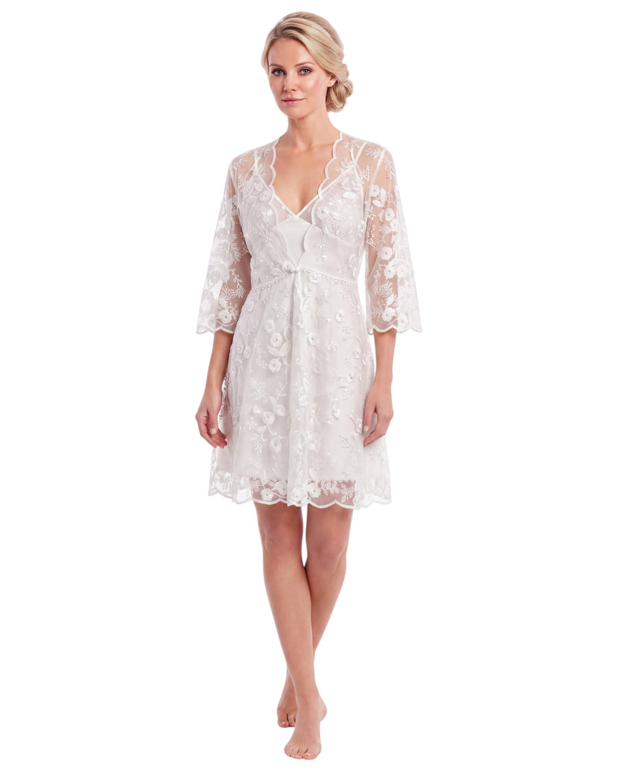 A woman modeling a short white lace robe with three-quarter sleeves and a V-neckline