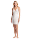 A blonde woman modeling a short white slip dress with lace cups and thin spaghetti straps