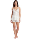 A woman modeling a white two-piece lingerie set consisting of a camisole top with lace trim and matching shorts