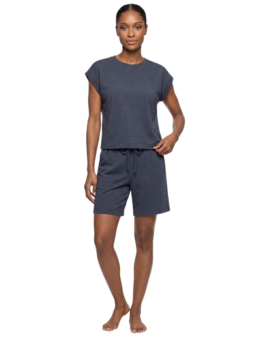 Model wearing a navy blue active lounge set with a sleeveless relaxed-fit top and matching drawstring shorts.