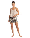 Woman wearing a beige tank top and leaf print shorts 