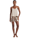 Woman wearing a beige tank top and patterned shorts 