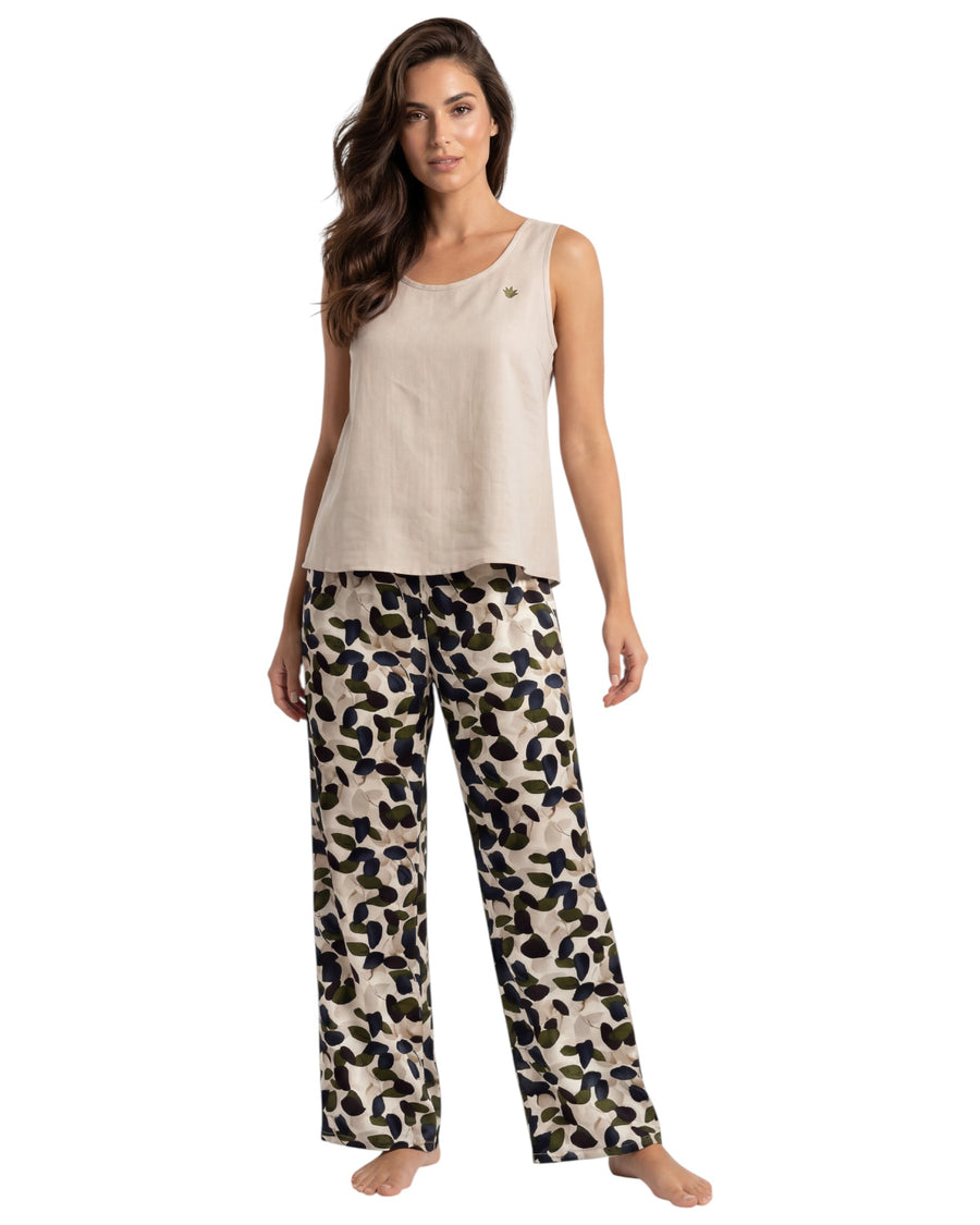 Woman wearing a beige tank top and leaf print pants 