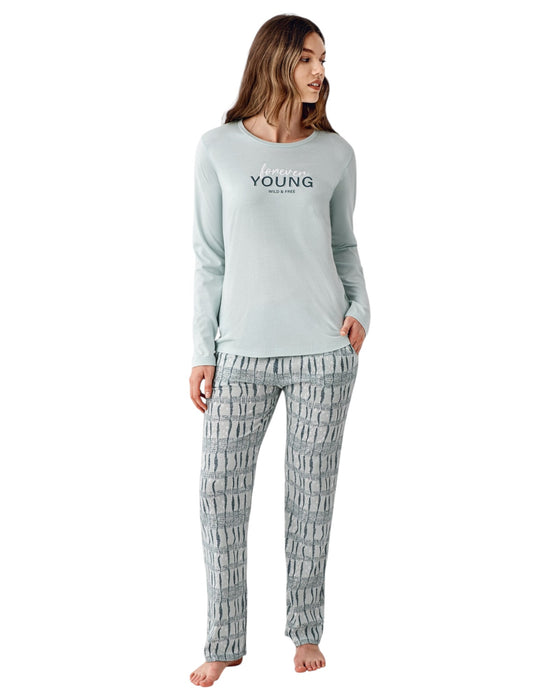 Woman wearing a light green long-sleeve top and patterned pants 