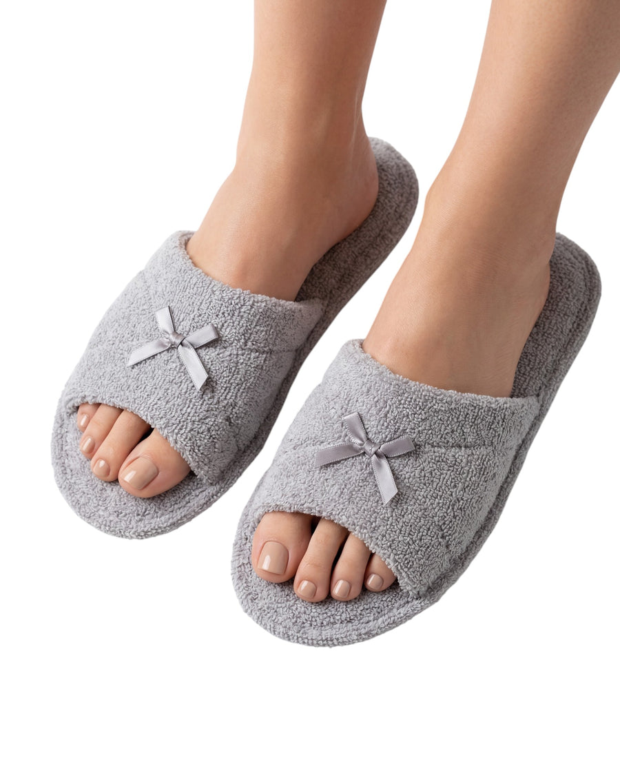 Soft grey home slippers with plush textured fabric and satin bow details.