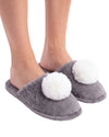 A pair of plush gray slip-on slippers with large white pom-pom details
