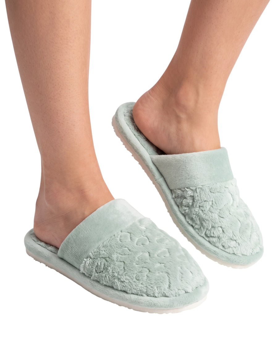 A pair of pale mint green plush slip-on slippers with textured floral embroidery on the upper