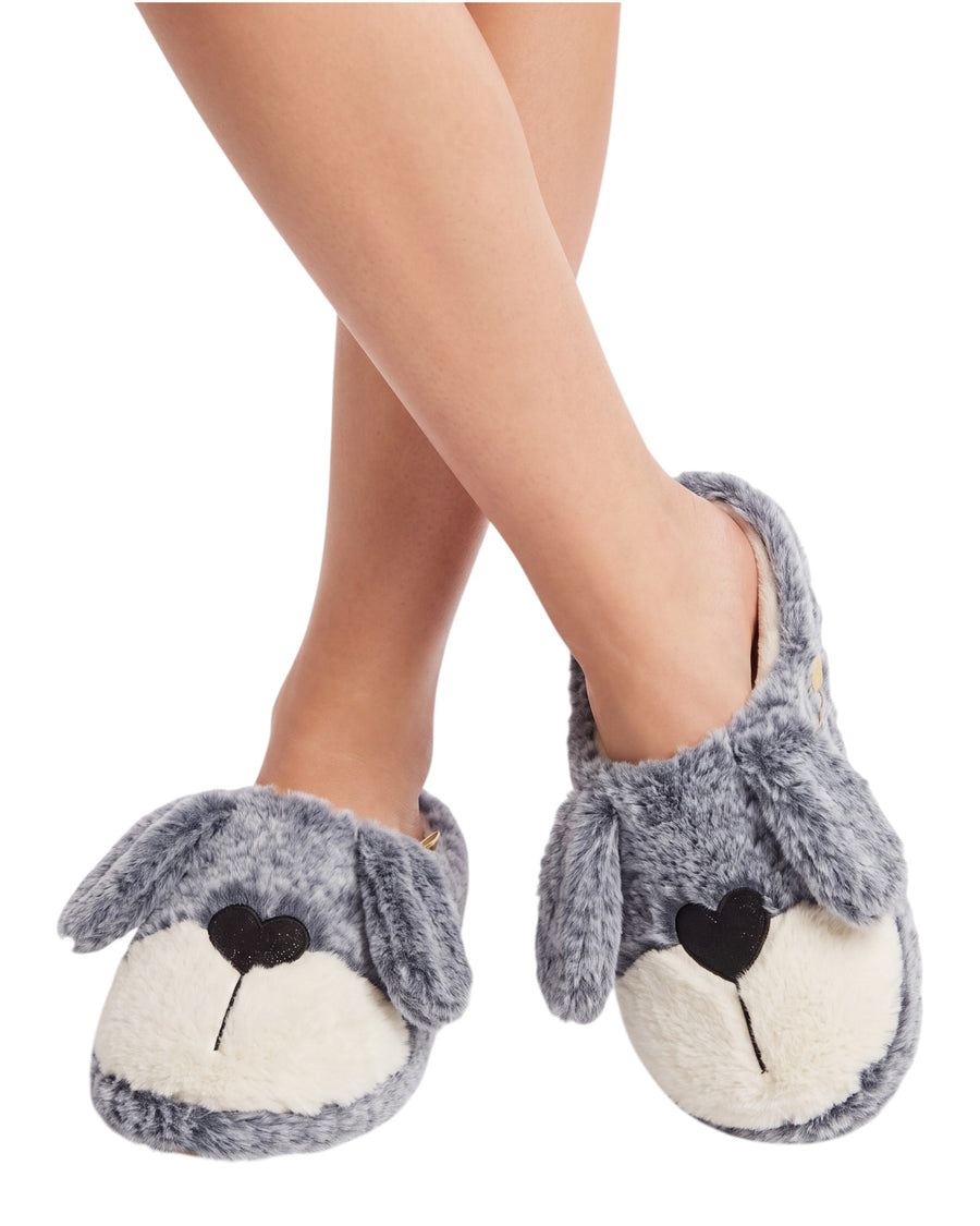 A pair of plush dog-face slippers worn on feet