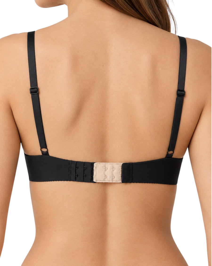 Back view of a woman wearing a black bra with adjustable shoulder straps and a beige hook-and-eye closure at the center of the band.